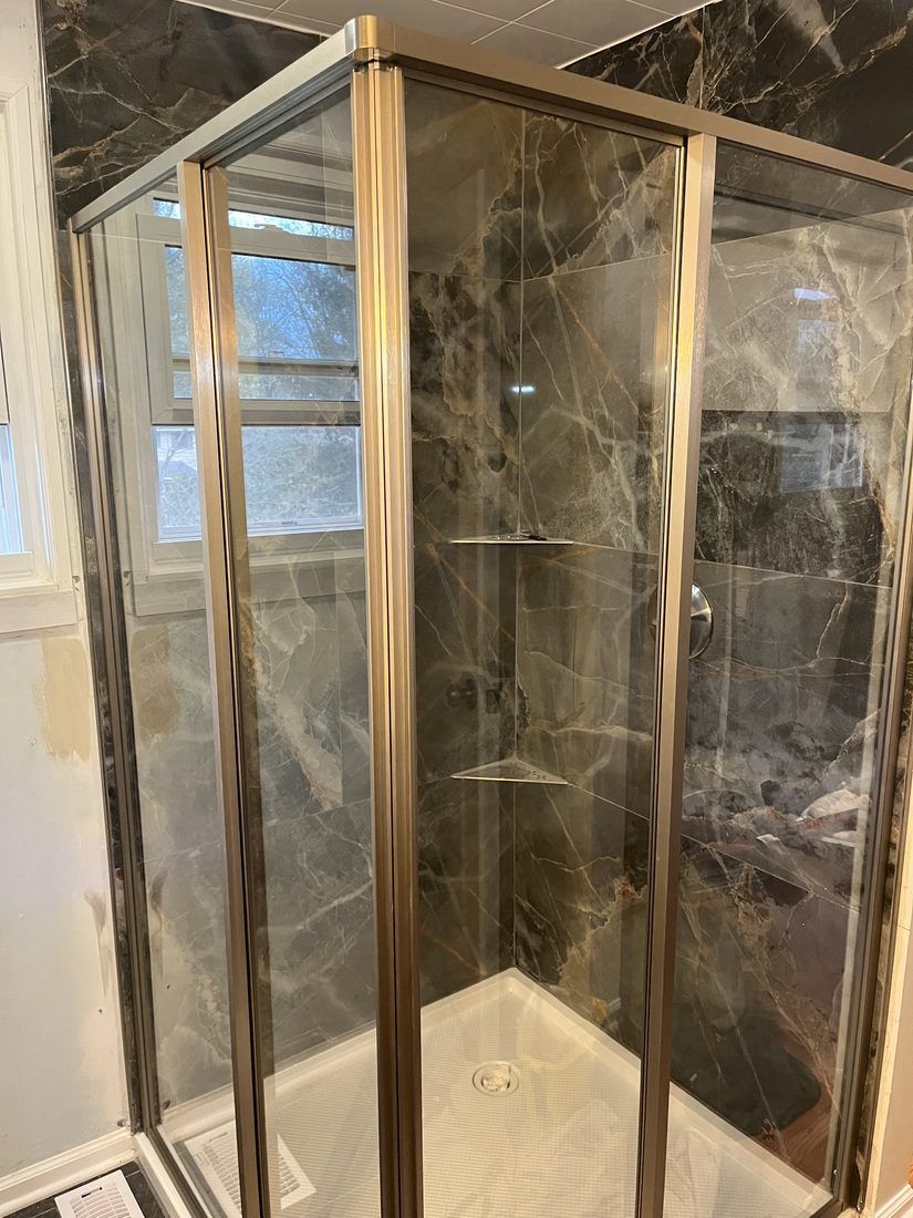 Marble-look shower with bronze enclosure